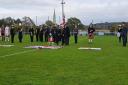 Sue and Martyn Sawyer stand either side of Carol Lake to honour their sons at Oxhey Jets' annual Remembrance match on Saturday