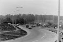 The roundabout viewed from the end of the M25 with cars turning left on to what became the slip road leading to the M25