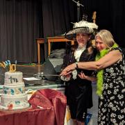 Annie Brewster cutting the cake with her sword
