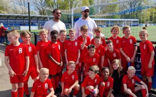 Anton and Rio Ferdinand with a team of young footballers.